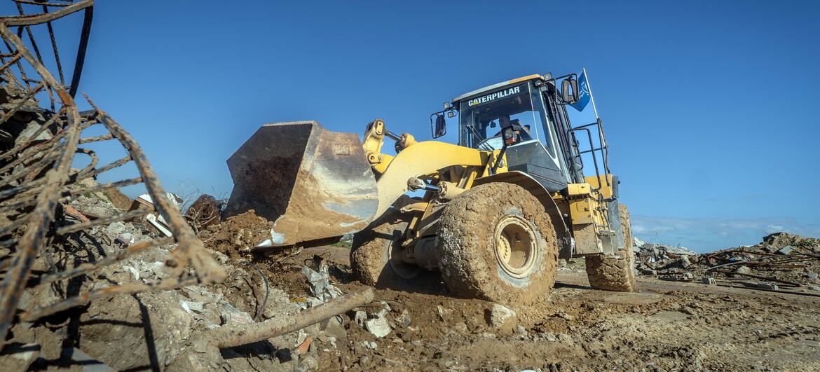 Un chargeur jaune Caterpillar travaille au milieu des décombres et des débris à Wadi Gaza, où le Programme alimentaire mondial a érigé une barrière de sable pour protéger les communautés des inondations.
