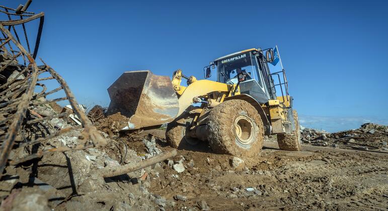 Chombo cha kupakia rangi ya manjano cha Caterpillar kinafanya kazi katikati ya mabomoko na takataka huko Wadi Gaza, ambako Shirika la Chakula Duniani limejenga kizuizi cha mchanga ili kulinda jamii kutokana na mafuriko.