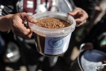 Un hombre en Gaza sujeta una comida repartida por el Programa Mundial de Alimentos