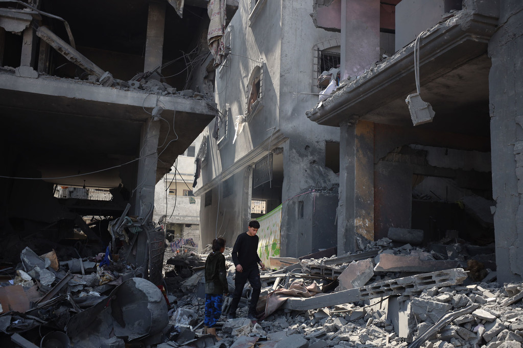 Two Gazans walk through a bomb site following renewed attacks on the enclave.