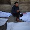 Un hombre sentado entre bolsas para cadáveres en Gaza, tras la reanudación de los ataques aéreos.