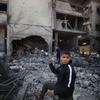 Un enfant devant un bâtiment détruit à Gaza.