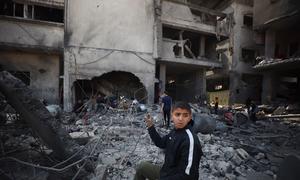 Un niño se detiene ante un edificio destruido en Gaza.