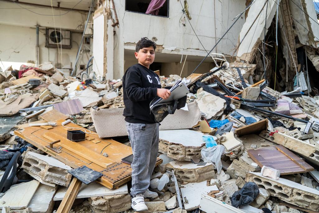 طفل يزور ما تبقى من منزل جده في بيروت بعد إعلان وقف إطلاق النار في لبنان.