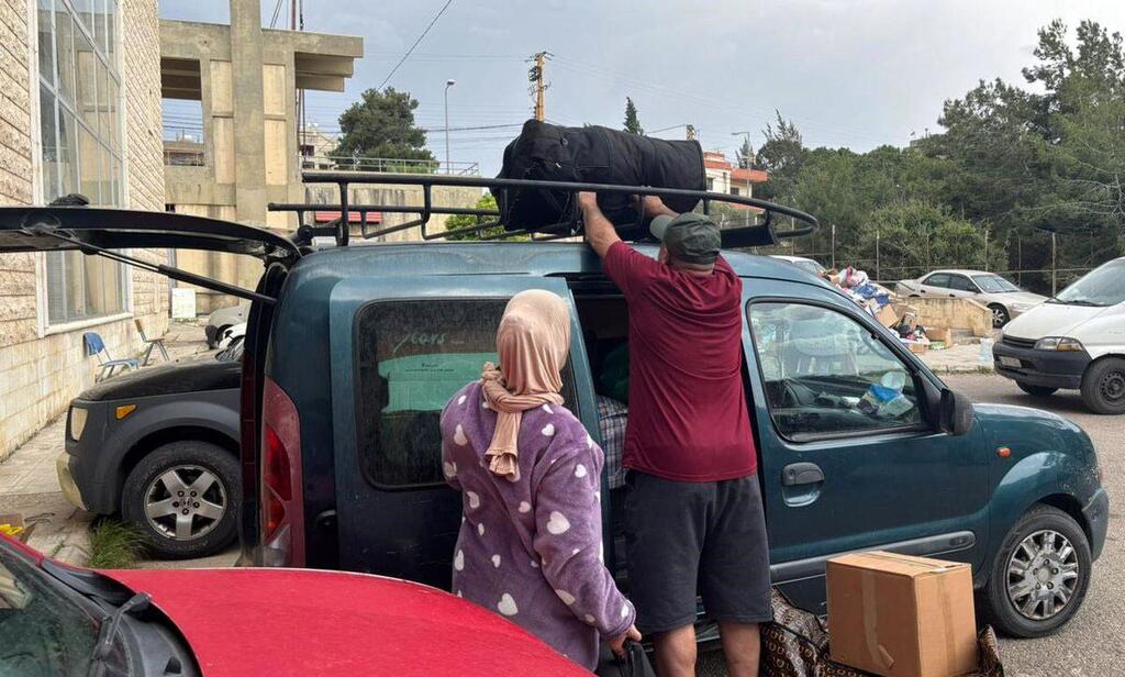 عائلة نازحة تحزم أمتعتها في سيارتها في أحد الملاجئ جنوب شرق بيروت، استعدادا للعودة إلى منزلها عقب الإعلان عن وقف إطلاق النار.