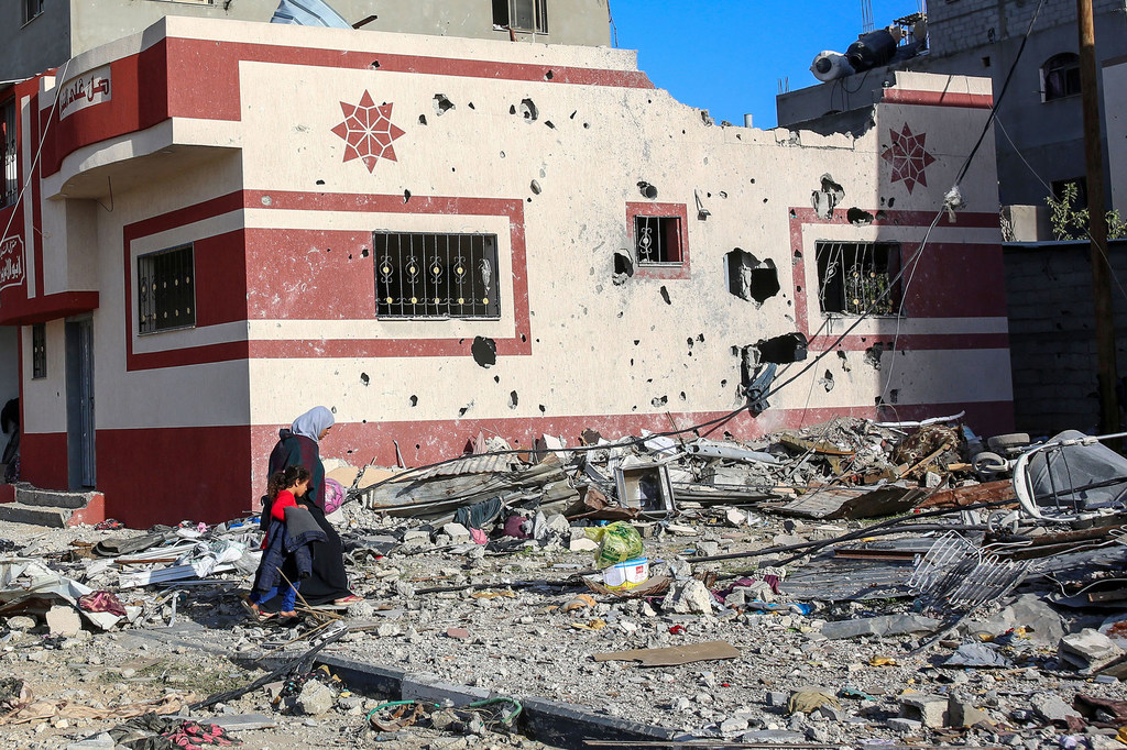 A woman and child walk through the heavily bombed town of Khuza’a in the Gaza Strip.