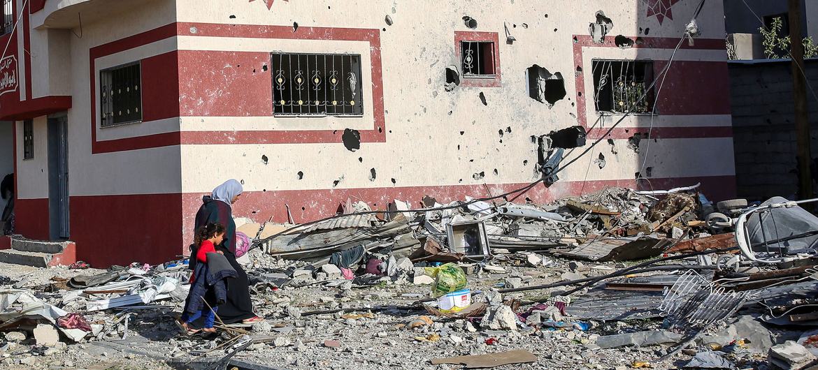 A woman and child walk through the heavily bombed town of Khuza'a in the Gaza Strip. A woman and child walk through the heavily bombed town of Khuza'a in the Gaza Strip.