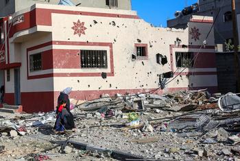 A woman and child walk through the heavily bombed town of Khuza’a in the Gaza Strip.