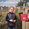 Veronika, 4, stands near a sign that reads "Danger of Mines". Chistovodivka, Kharkiv region, Ukraine (file, May 2025)