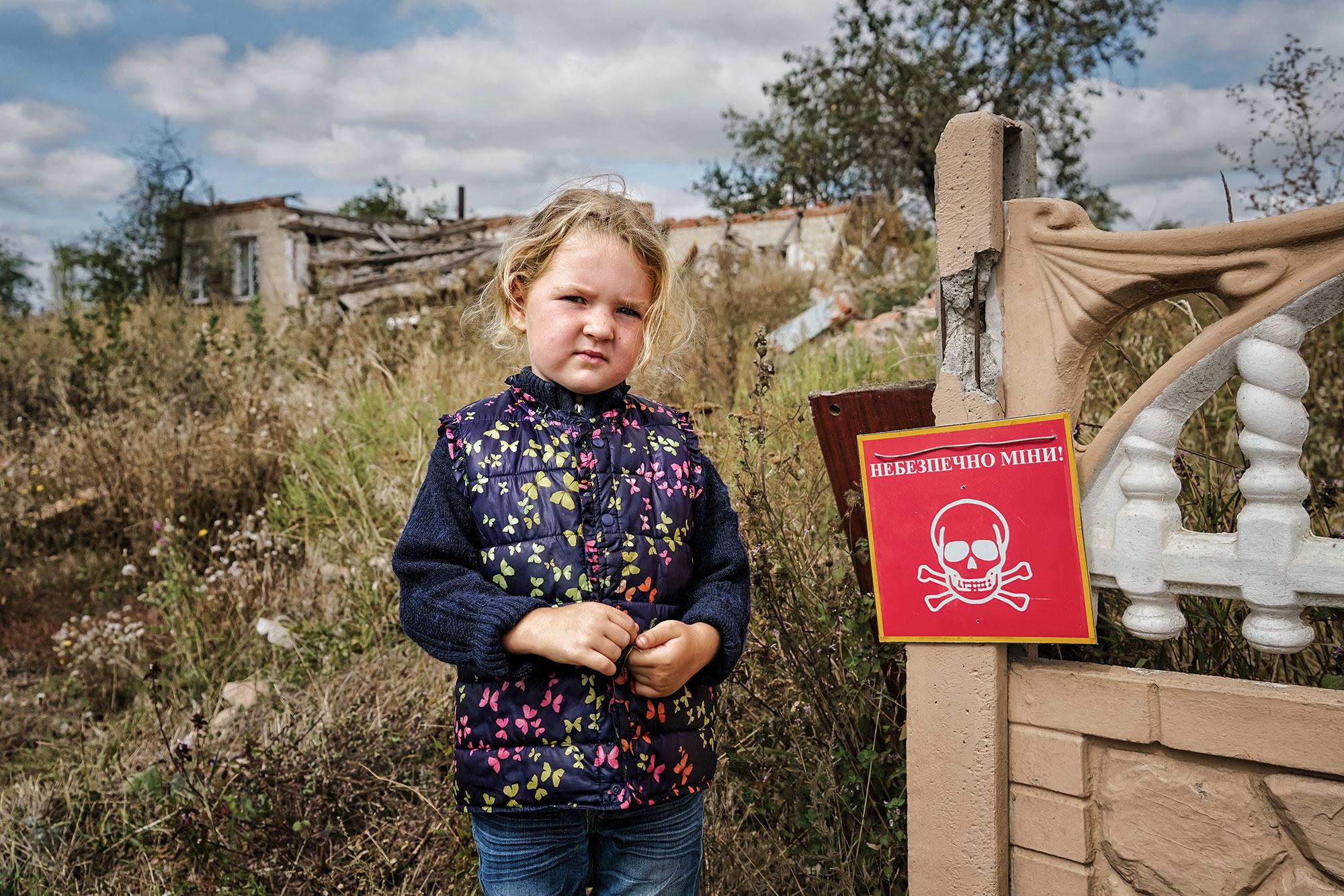 Veronika, 4, stands near a sign that reads "Danger of Mines". Chistovodivka, Kharkiv region, Ukraine (file, May 2025) Veronika, 4, stands near a sign that reads "Danger of Mines". Chistovodivka, Kharkiv region, Ukraine (file, May 2025)