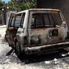 Un SUV brûlé garé dans une rue poussiéreuse d'un quartier résidentiel de Port-au-Prince, en Haïti, à la suite d'affrontements armés.