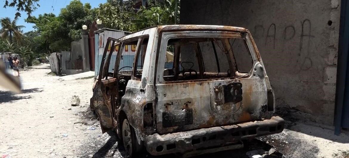 A burnt-out SUV parked on a dusty street in a residential area of Port-au-Prince, Haiti, following armed clashes.