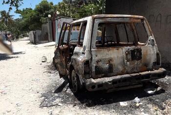 Un SUV brûlé garé dans une rue poussiéreuse d'un quartier résidentiel de Port-au-Prince, en Haïti, à la suite d'affrontements armés.