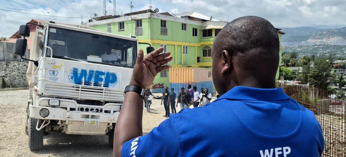 A WFP worker directs a food truck in Port-au-Prince, Haiti, as residents flee nearby armed clashes.