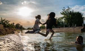 Unos niños saltan a un canal en el centro de Vietnam.