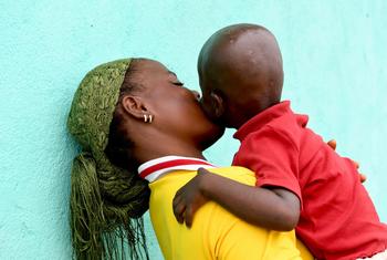 Una madre, con su hijo de dos años en brazos en Costa de Marfil, descubrió que era seropositiva durante el embarazo.