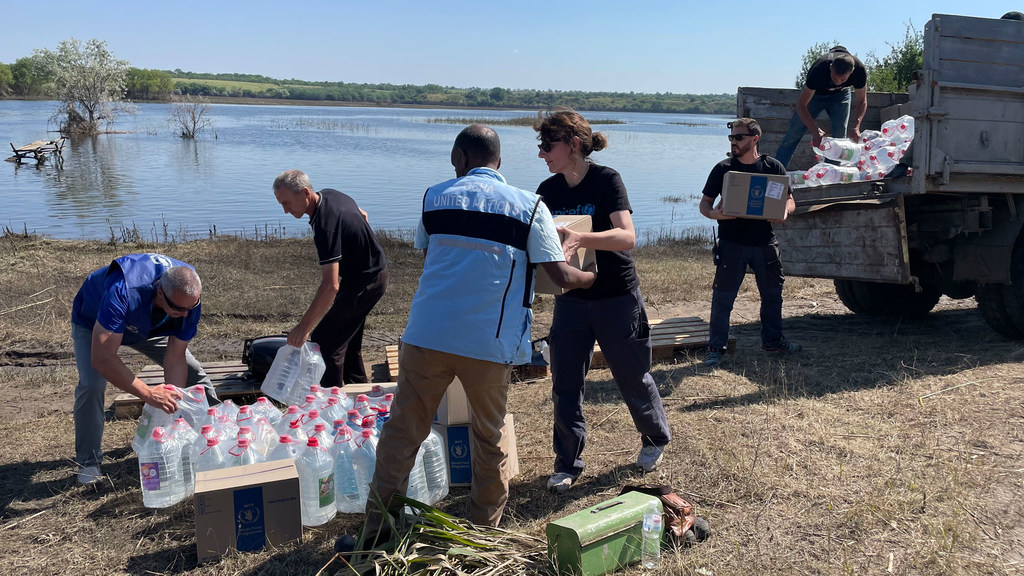 De la nourriture et de l'eau sont livrées par le personnel de l'ONU de l'autre côté d'une rivière en Ukraine à une communauté à 15 kilomètres de la ligne de front.