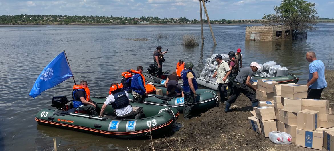 Food and water aid is delivered by dinghy to a small village near Kherson, Ukraine, about 15 kilometres from the front line