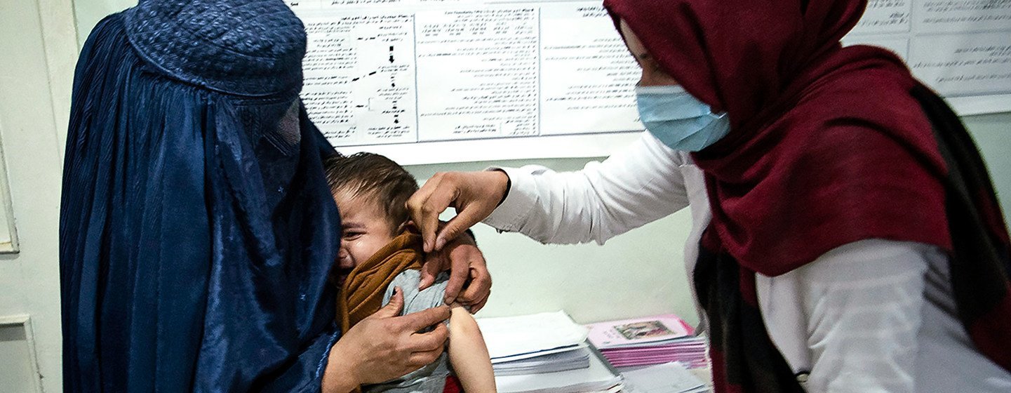 अफ़ग़ानिस्तान के परवान प्रान्त में एक स्वास्थ्यकर्मी एक बच्चे की स्वास्थ्य जाँच करते हुए. (नवम्बर 2020)
