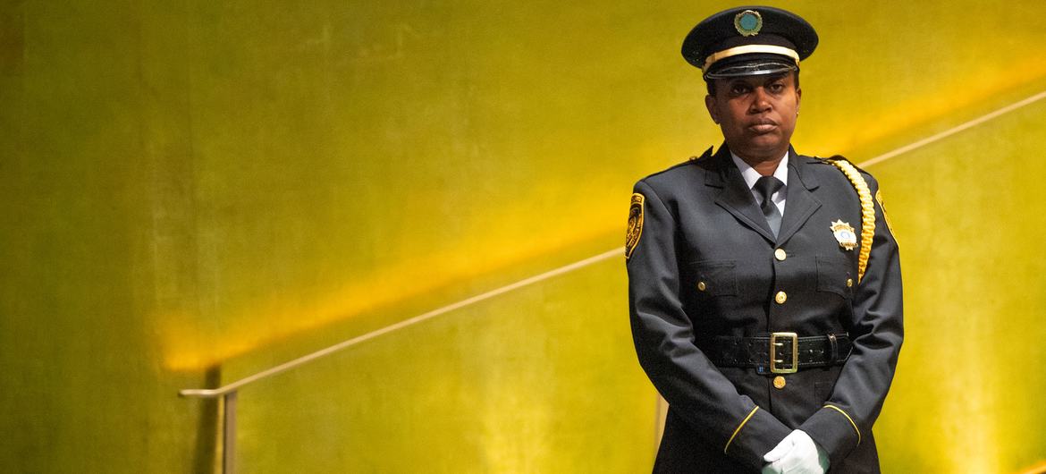 A United Nations security officer stands at the foot of the podium stairs in the General Assembly Hall.