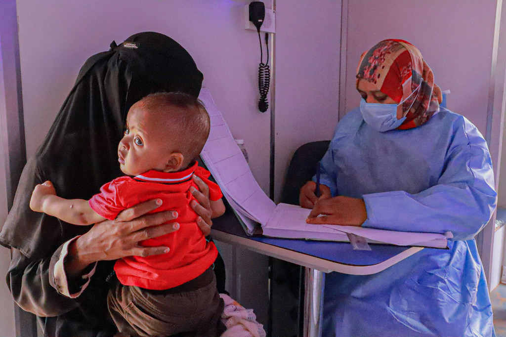 A Sudanese refugee takes her baby for a health check in Alkufra in eastern Libya.