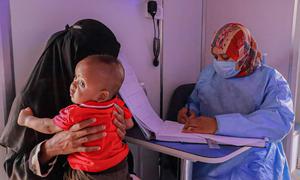 A Sudanese refugee takes her baby for a health check in Alkufra in eastern Libya.