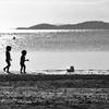 Des enfants marchent sur une plage en Nouvelle-Calédonie, territoire français d'outre-mer situé dans le Pacifique Sud.
