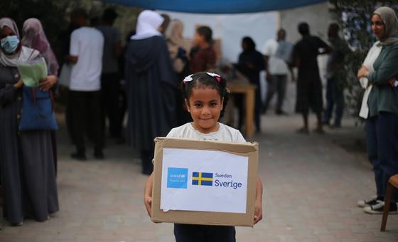 A child in Gaza carries a box of winter clothes.