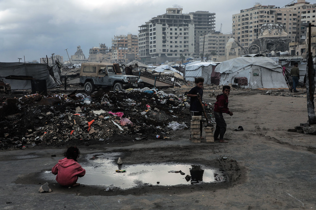 一名加沙儿童在水坑中玩耍。

