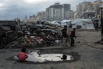 A child plays in a puddle in the Al-Rashid Street area of Gaza.