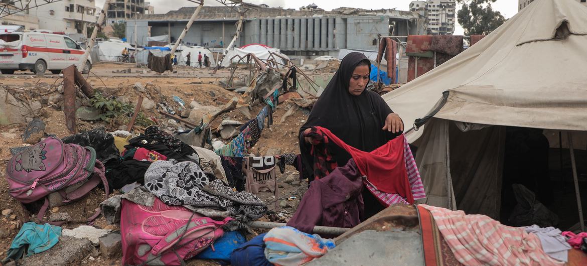 A woman sorts through clothes outside a tent in Gaza City.