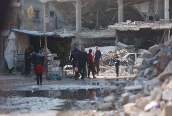 People walk through a destroyed neighbourhood of Gaza City.
