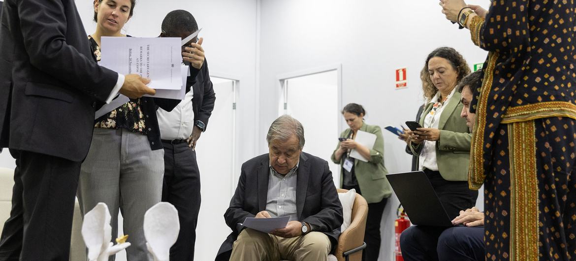 The UN Secretary-General António Guterres (centre) reviews documents with his colleagues at the UN Climate Conference in Brazil.