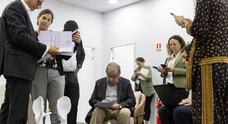 联合国秘书长安东尼奥·古特雷斯（中）在巴西联合国气候大会上与同事审阅文件。