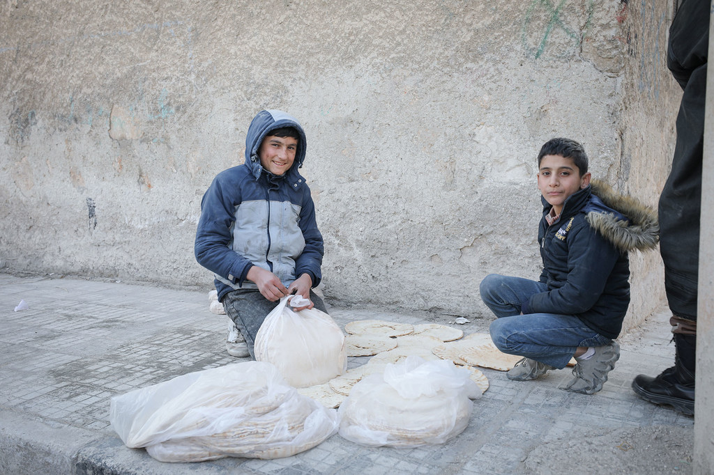 Deux garçons vendent du pain dans les rues d'Alep en Syrie.