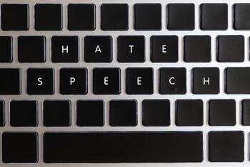 A close-up of a computer keyboard with the words ‘HATE SPEECH’ written on the keys.