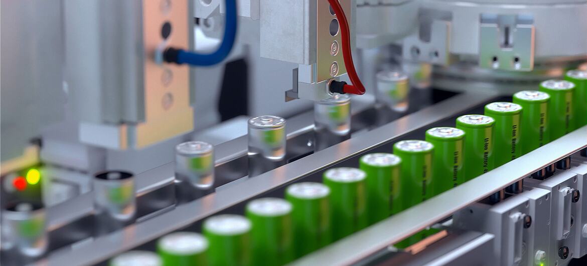 Des batteries lithium-ion vertes défilent sur une chaîne de convoyage automatisée dans une usine moderne.