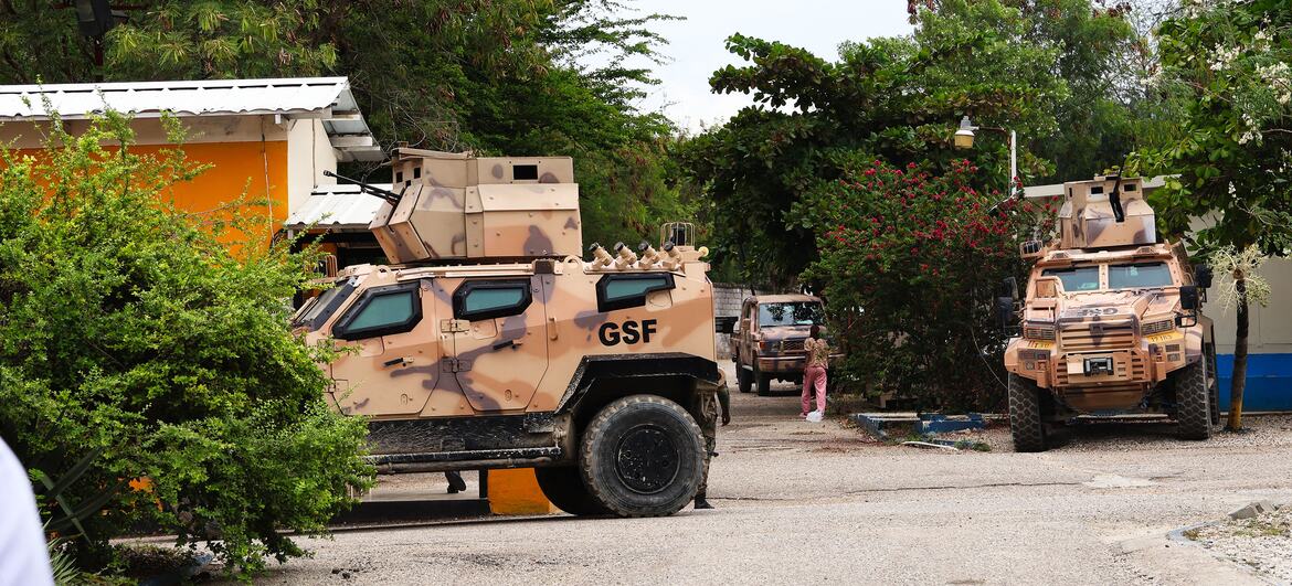 Vehículos militares blindados con distintivos de las Fuerzas de Seguridad General (GSF) están estacionados en un camino de grava en una base militar en Haití.