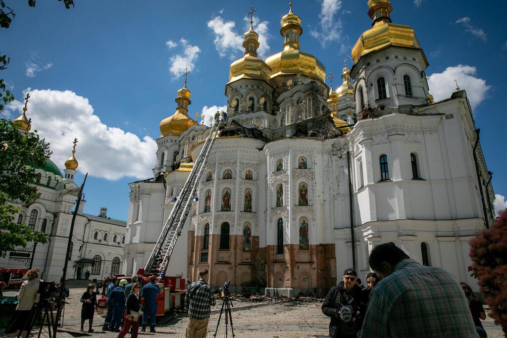 Bomberos y periodistas en el dañado monasterio de Kyiv Pechersk Lavra en Kiev, Ucrania.