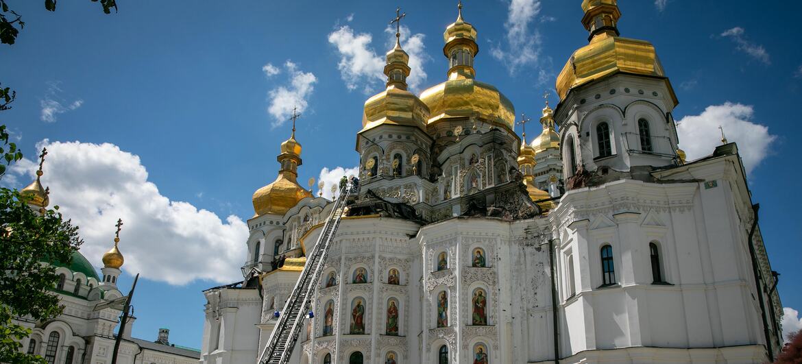 Firefighters and journalists at the damaged Kyiv Pechersk Lavra in Kyiv, Ukraine.
