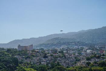 UNHAS helicopter flying over the Port-au-Prince urban landscape in Haiti.