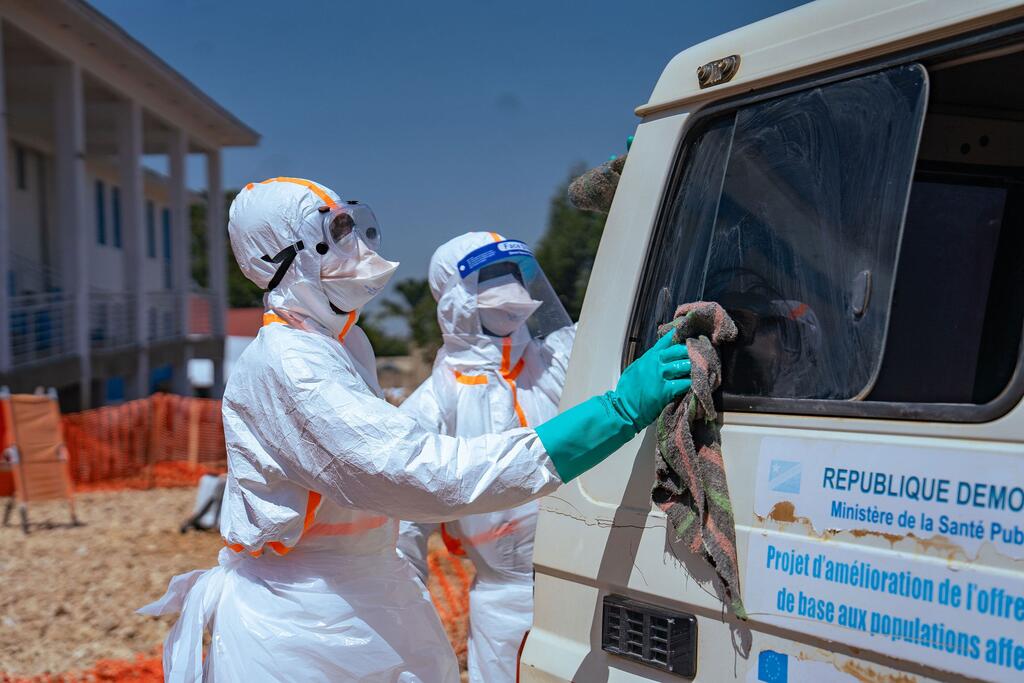 Des agents de santé de l'OMS, vêtus d'équipements de protection, nettoient un véhicule lors d'une opération de lutte contre Ebola en République démocratique du Congo.