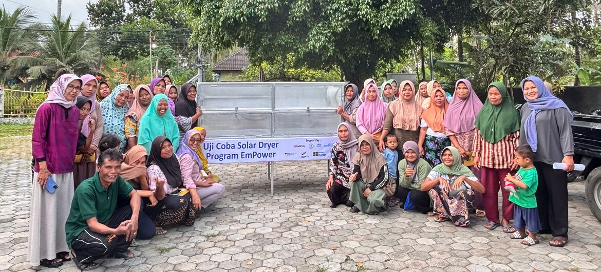 A group of people pose for a photo with a solar dryer prototype in West Nusa Tenggara, Indonesia.