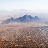Aerial view of a large settlement in a desert landscape with mountains in the background, identified as Kassala, Sudan.