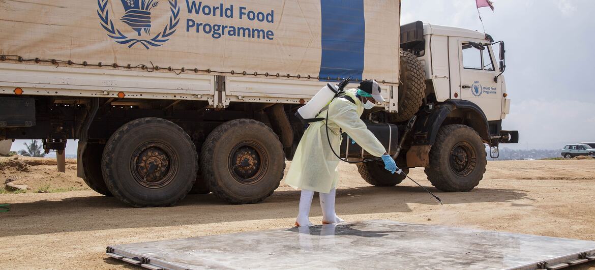 Un employé du Programme alimentaire mondial désinfecte une palette d'avion à l'aéroport de Bunia, en RDC.