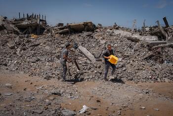 Amjad and a colleague clear rubble in Jabalia, Gaza, to make space for displaced families.