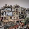 Damaged buildings in Sheikh Radwan, Gaza City, showing destruction and bullet holes on the facades.