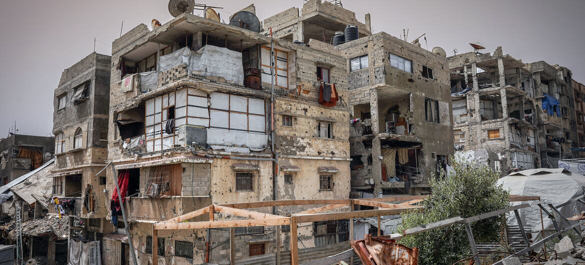Damaged buildings in Sheikh Radwan, Gaza City, showing destruction and bullet holes on the facades.