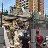 Des secouristes équipés de tenues de sécurité évaluent les décombres d'un immeuble effondré au Venezuela à la suite d'un tremblement de terre.