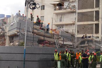Emergency response personnel and rescue workers assess damage at a collapsed building in Caracas, Venezuela, after the June 24th earthquakes.